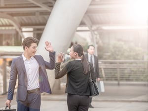 A man and a woman wave goodbye