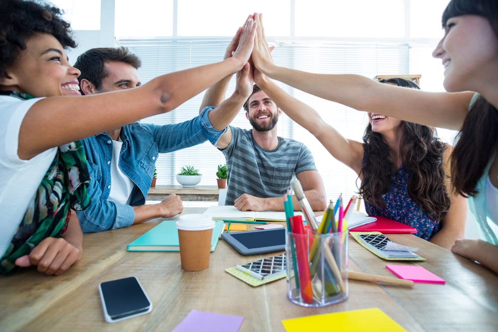 Creative business team putting hands together at the office-1